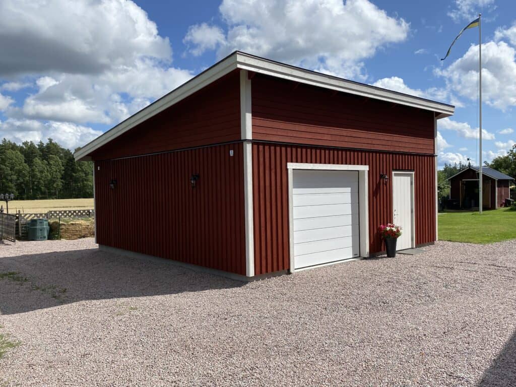 enkelgarage med en garageport, en dörr och pulpettak med TRP20